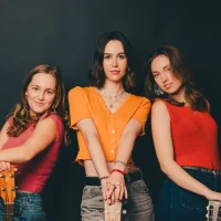 Die Bandmitglieder von Mille. Drei junge Frauen mit Gitarren.